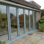 Large glazed aluminium bi-fold door system installed at the rear of a home