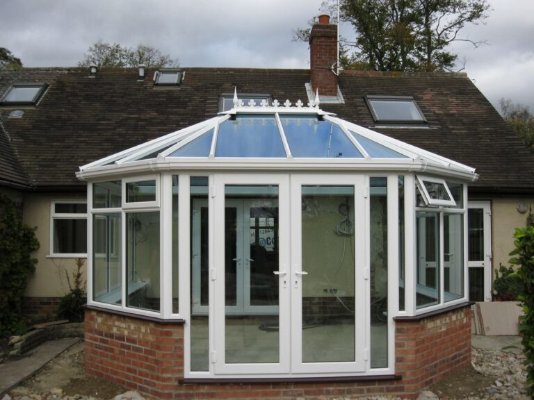 Traditional Victorian conservatory with ornate, angled roof sections and large uPVC windows, offering a charming and light-filled garden room that combines classic elegance with modern durability.