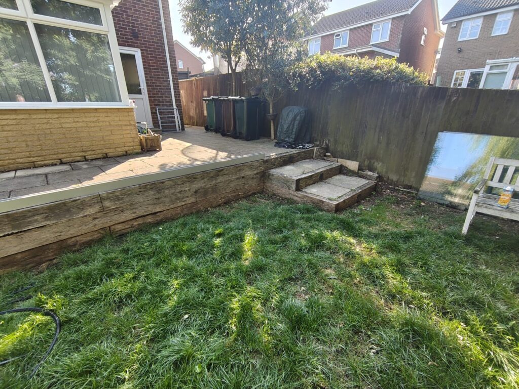 old step paving slab to be replaced and wooden sleepers around the steps