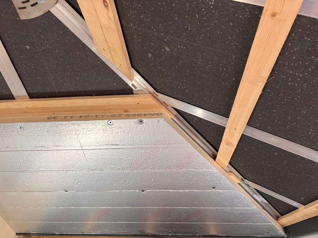 Warm roof construction showing insulation layers being installed in a conservatory on the inside showing 2 layers