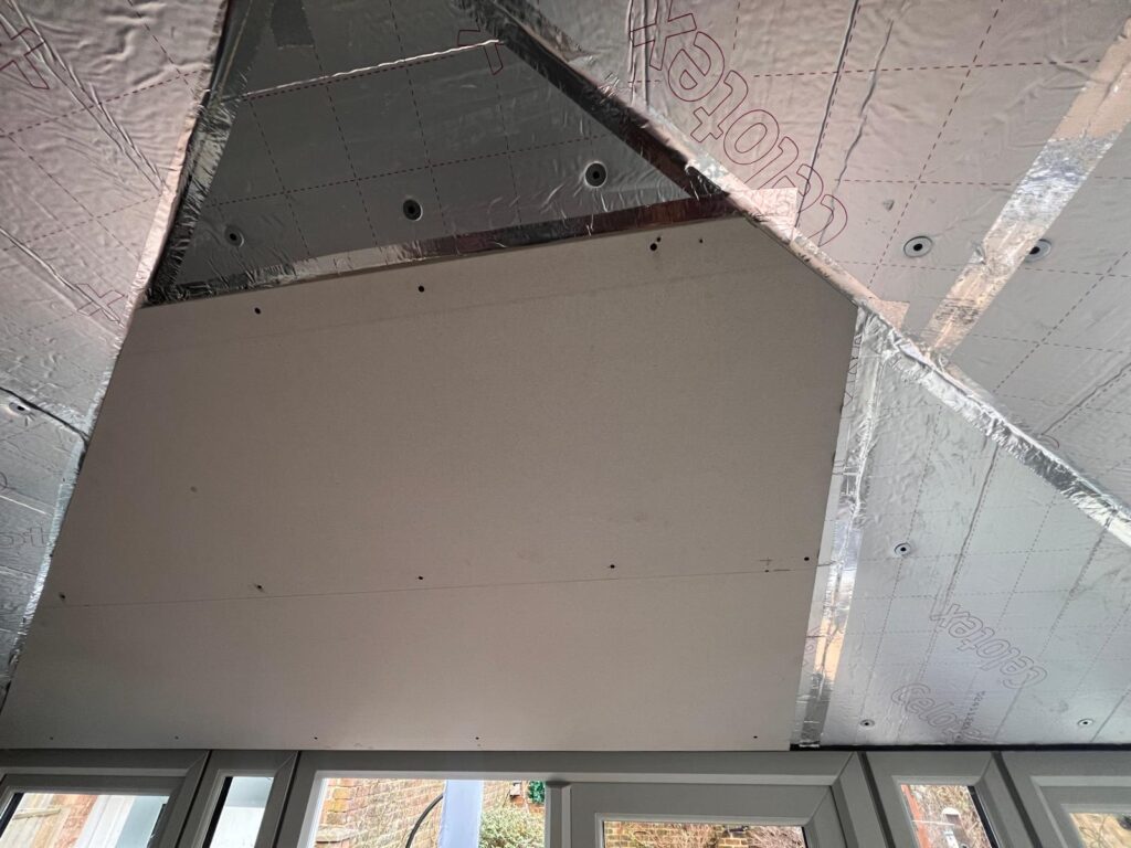 warm roof construction show plasterboards going up after the insulation being installed