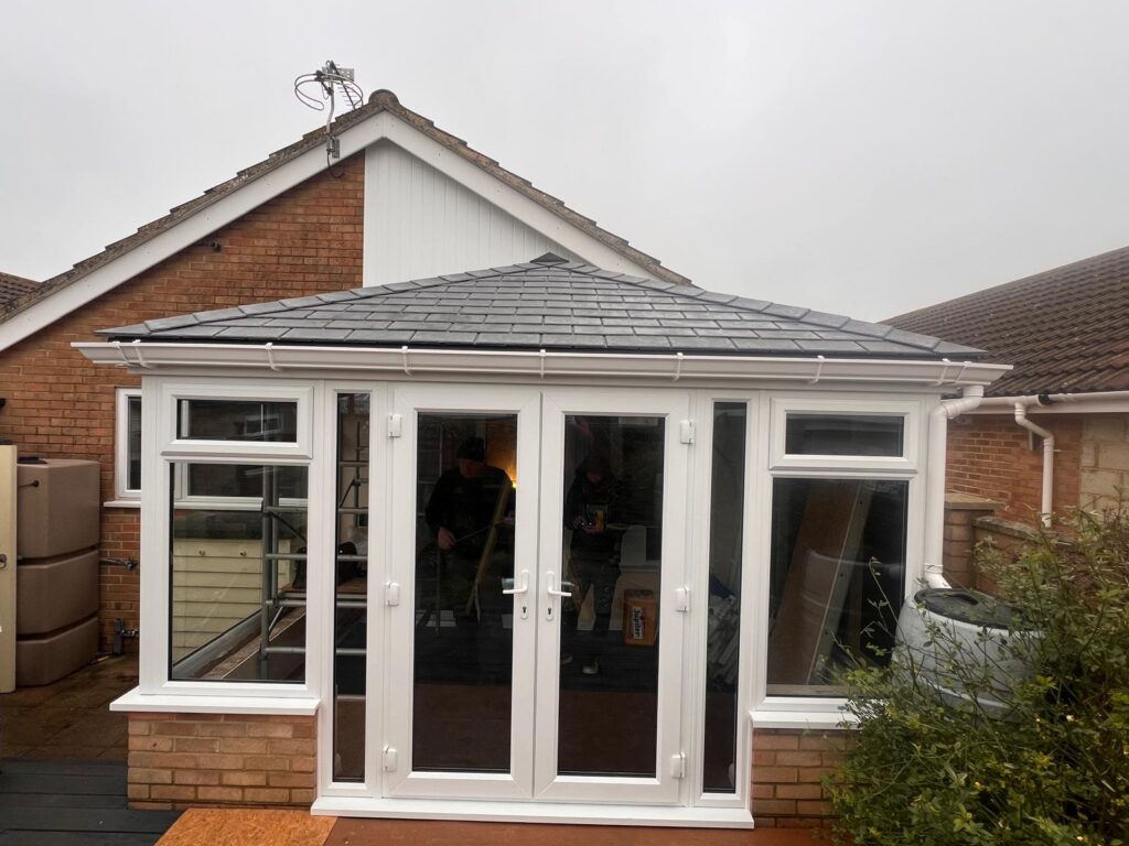 Completed flat warm roof conservatory installation with tiled finish with a front view and new upvc products
