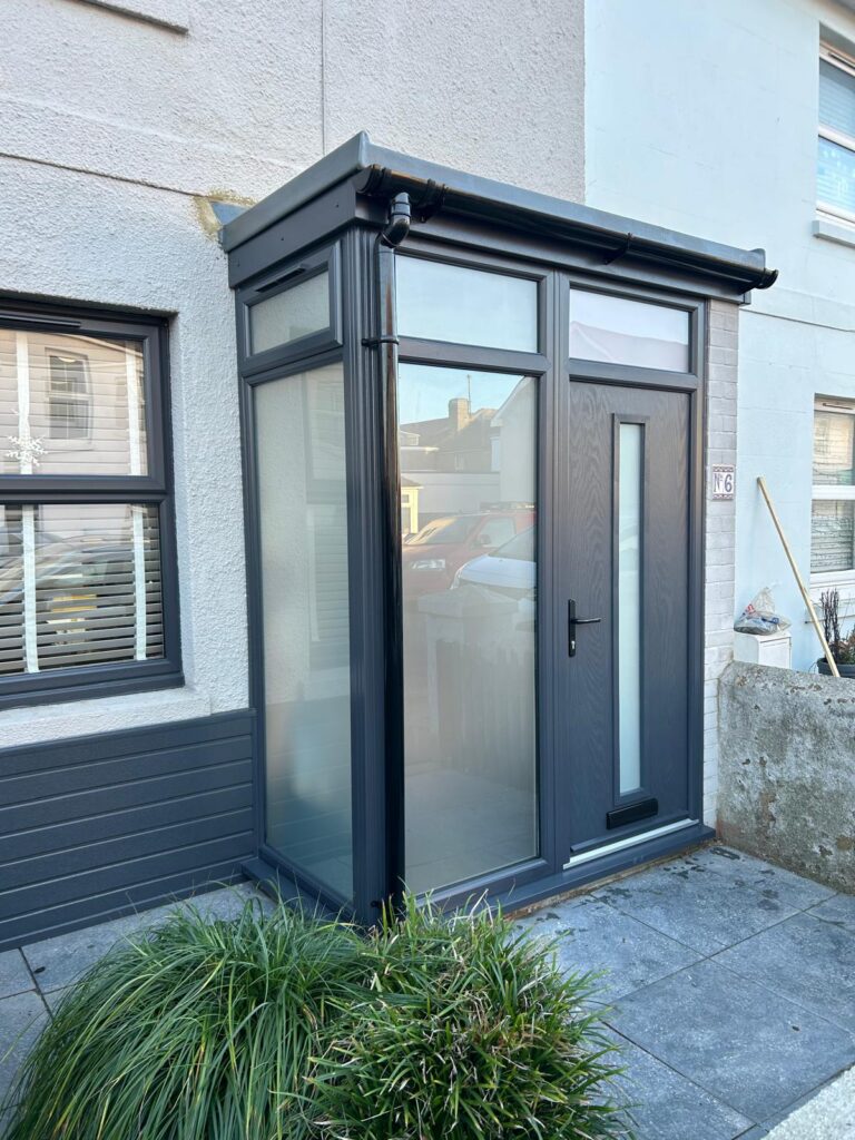 New extended porch in Eastbourne with an anthracite grey composite door, floor-to-ceiling windows and fibreglass flat roof.