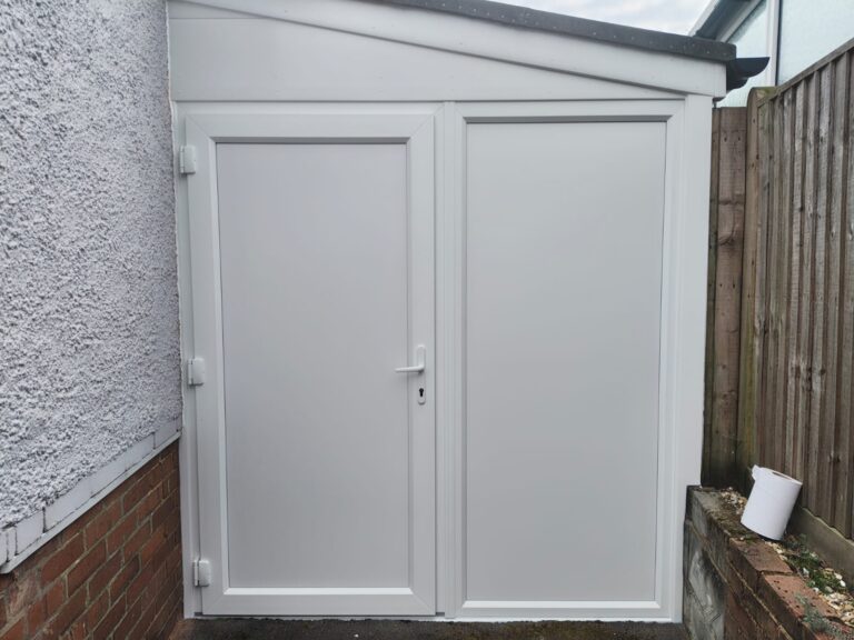 New white uPVC garage door and solid side panel installed in Bexhill to replace the old garage doors.