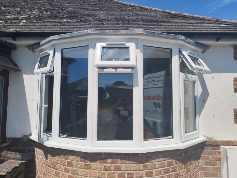 New white uPVC bay window installation in Polegate with double glazing and opening top windows.